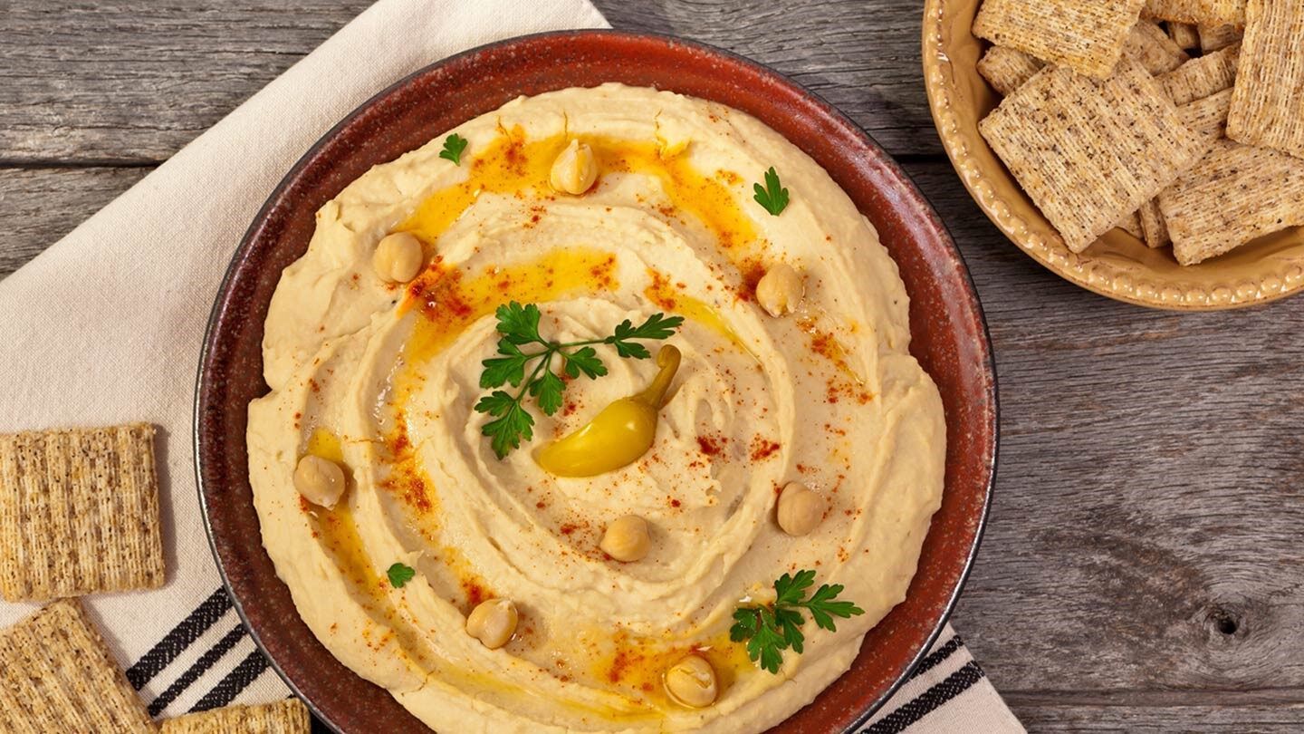 a plate of hummus with crackers